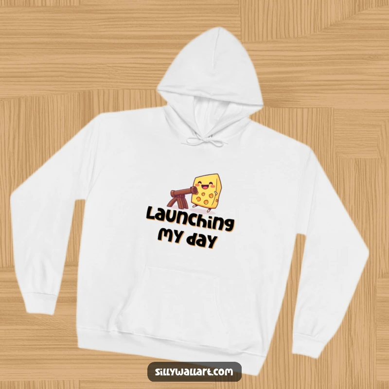 Funny grinning cheese launching from a catapult, featured on a cozy hoodie for warm, humorous, and adventurous wear.
